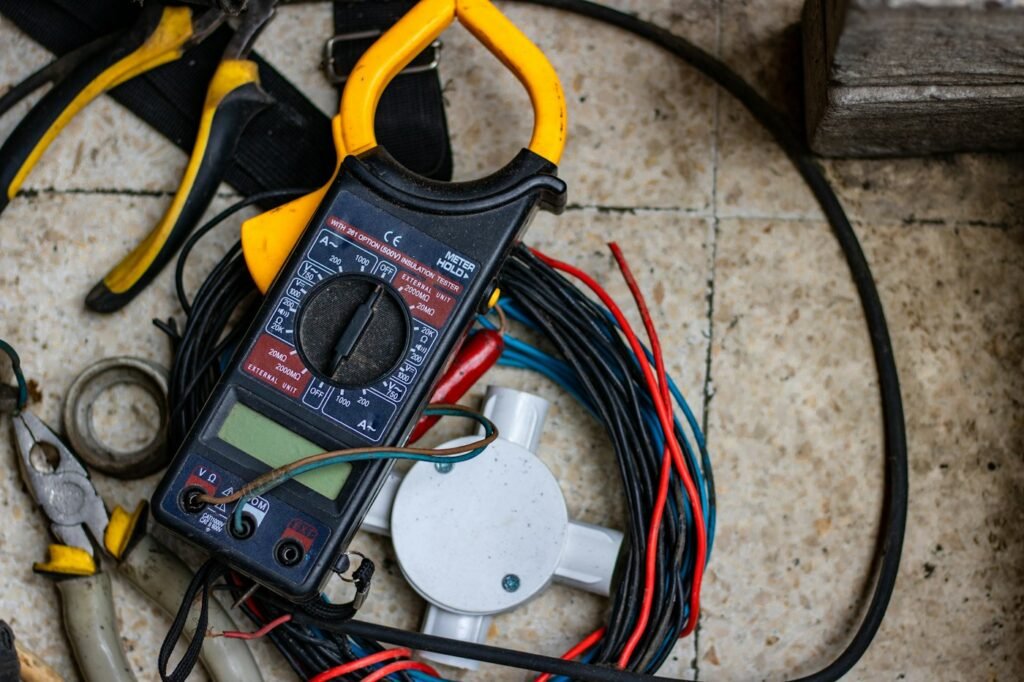 Pinza amperimétrica y cables de medición sobre una mesa de trabajo